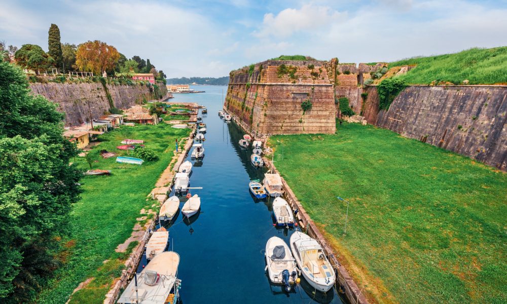 The Old Fortress Canal in Corfu Town, with its historic fortifications and charming boats, offers a glimpse into the island's rich past